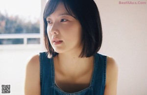 A woman with short black hair and a blue tank top.