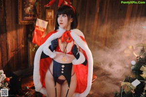 A woman in a red and black outfit sitting on a wooden floor.