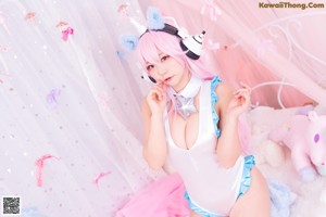 A woman with pink hair wearing a white and blue outfit.