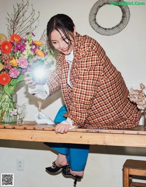 A woman eating sushi with red caviar on a plate.