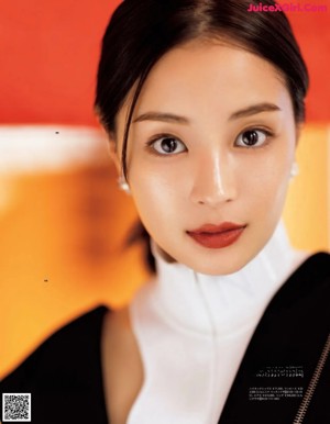 A woman sitting at a table with chopsticks in her hand.