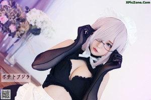A woman in a maid outfit posing on a dresser.