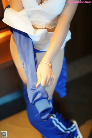 A woman in a blue and white jacket is posing for the camera.