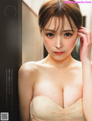 A woman in a beige bra is posing for the camera.