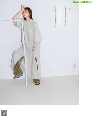 A woman standing in front of a white wall in a room.