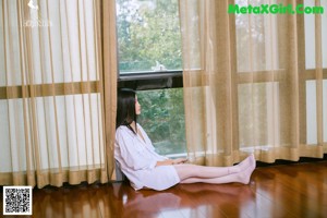 A woman sitting on the stairs of a house.