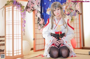 A woman in a kimono is sitting on the floor.