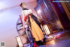 A woman in a kimono sitting on a chair.
