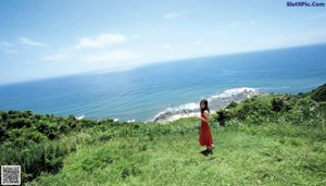 A woman in a red dress standing on a set of stairs.