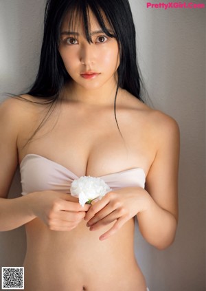 A woman in a white bikini posing on a bed.