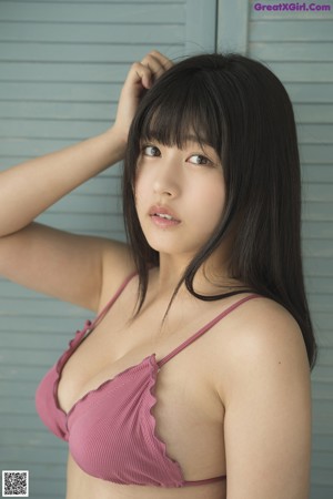 A woman in a pink bikini sitting on a set of stairs.