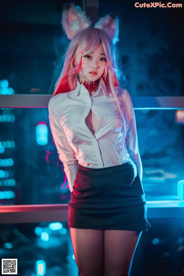 A woman in a white shirt and black skirt posing for a picture.