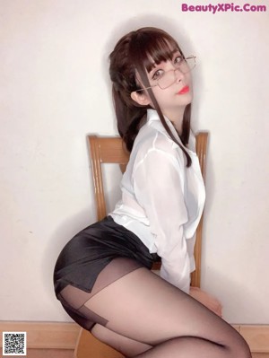 A woman wearing glasses and a white shirt.