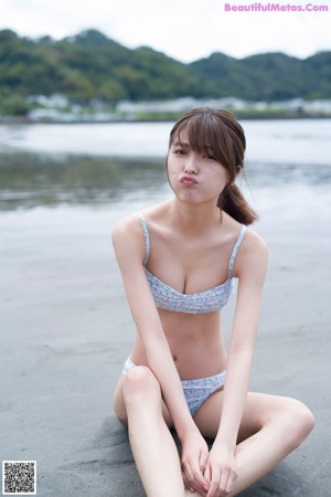 A woman standing in front of a body of water.