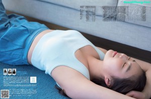 A woman laying on a couch with her eyes closed.