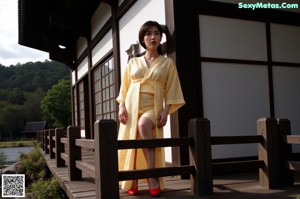 A woman in a purple dress sitting on a stone wall.