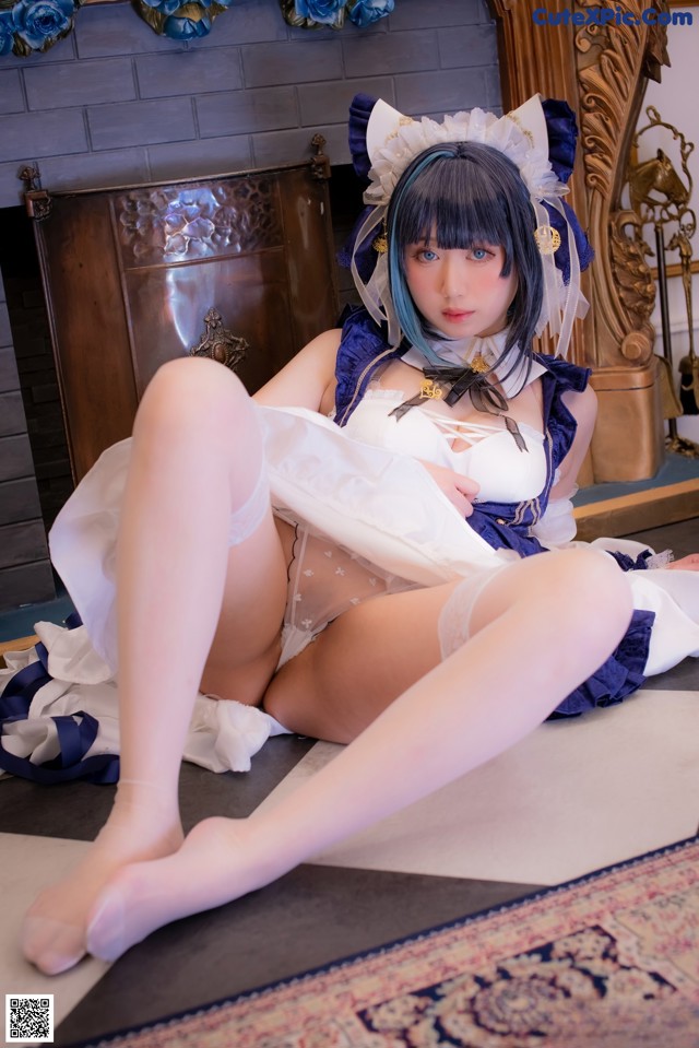 A woman in a maid outfit is sitting on the floor.